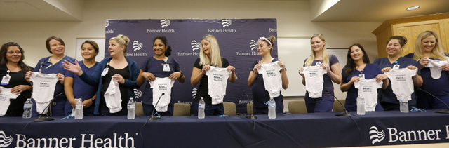 미국 애리조나주 메사시 배너데저트 병원의 중환자실 간호사 16명이 올가을부터 내년 초까지 줄줄이 출산을 앞두고 있다. 17일 간호사들이 병원 측이 선물한 아기 옷을 들어 보이고 있다. 메사=AP 뉴시스
