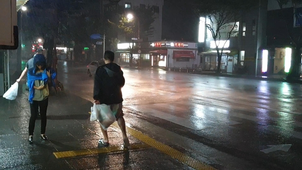 22일 오후 9시쯤 제주도 서귀포시내. 태풍 ‘솔릭’이 다가오며 비바람이 몰아치자 시민들이 걸음을 옮기기도 힘이드는 모습이다. /최상현 기자