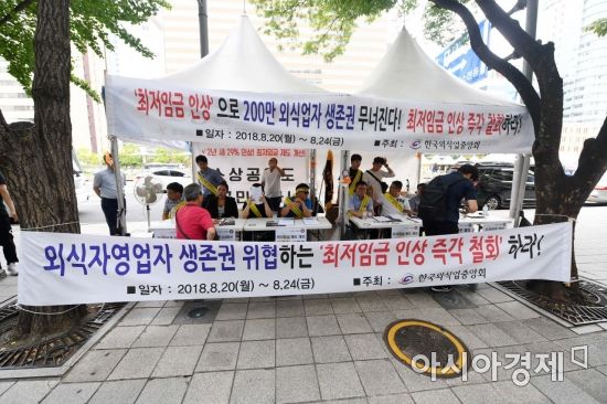 한국외식업중앙회 관계자들이 20일 서울 종로구 광화문광장에서 열린 제1차 최저임금 인상 규탄집회를 마친 뒤 최저임금 제도개선을 촉구하는 서명을 받고 있다. 이들은 "최저임금의 급격한 인상이 영세 자영업자에게는 사실상 사형 선고"라며 "정치권과 정부가 자영업자 생존권 보장을 위한 종합 대책을 마련해 달라"고 요구했다. /문호남 기자 munonam@