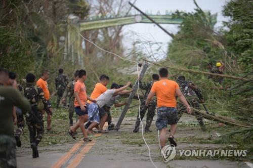 슈퍼태풍 영향으로 전봇대와 가로수가 무너진 필리핀 도로[AFP=연합뉴스]