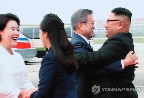[평양정상회담] 평양포옹 (서울=연합뉴스) 진성철 기자 = '2018남북정상회담평양'의 첫날인 18일 평양 순안공항에 도착한 문재인 대통령이 마중 나온 김정은 북한 국무위원장과 포옹하는 장면이 이날 서울 중구 DDP 메인프레스센터에 중계되고 있다.     zjin@yna.co.kr  (끝)