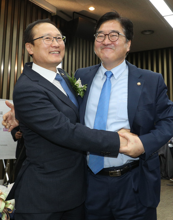 지난 5월 11일 더불어민주당 원내대표에 당선된 홍영표 원내대표(왼쪽)가 우원식 전 원내대표에게 축하를 받고 있다. [중앙포토]