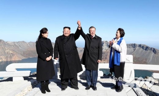  평양정상회담 사흘째인 20일 오전 문재인 대통령과 김정은 국무위원장이 백두산 정상인 장군봉에 올라 손을 맞잡아 들어올리고 있다. 2018.9.20 / 평양사진공동취재단