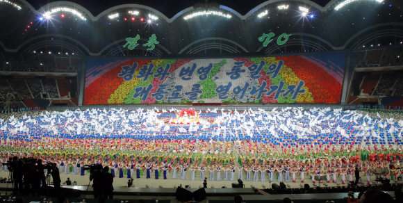 능라도 5·1 경기장에서 열린 ‘빛나는 조국’ 공연 모습. 경기장 뒤로 ‘평화와 번영, 통일의 대통로를 열어나가자’는 대형 카드 섹션이 펼쳐지는 가운데 공연 참가자들이 한반도기를 흔들고 있다.평양사진공동취재단