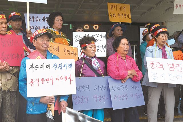 지난 21일 경북 청송군청 앞에서 열린 풍력발전 반대 기자회견에서 주민들이 팻말을 들고 있다. 이상돈 의원실 제공