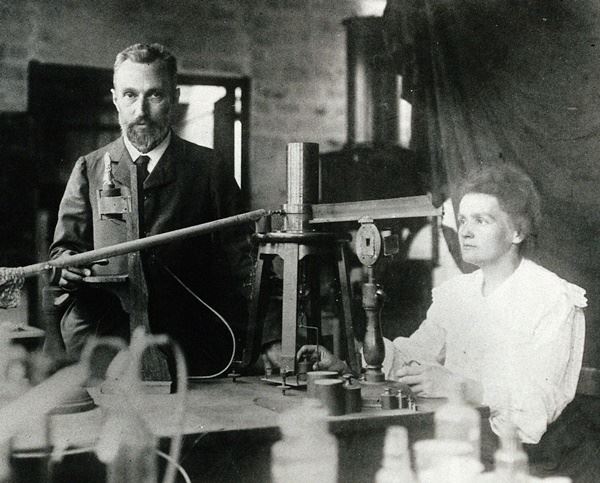 남편 피에르 퀴리(왼쪽)과 함께 파리의 연구실에 앉아 있는 마리 퀴리. 위키백과