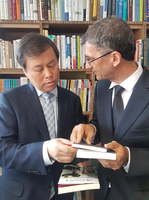 도종환 문화장관과 라 사피엔차 동양학 도서관장 (로마=연합뉴스) 현윤경 특파원 = 16일 이탈리아 로마 라 사피엔차 대학에서 열린 한국자료실 개관식에서 도종환 문화체육관광부 장관이 파비오 스타씨 동양학부 도서관장과 책을 주고 받고 있다. 2018.10.16