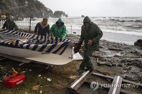 29일 강풍과 폭우가 닥친 이탈리아 친퀘테레 지역에서 주민들이 배를 옮기고 있다. [AFP=연합뉴스]