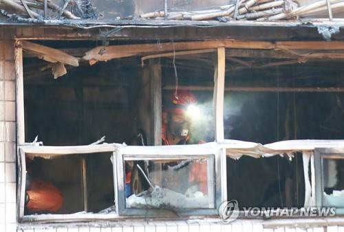 고시원 화재 진압 뒤에도 연기 자욱 (서울=연합뉴스) 홍해인 기자 = 9일 오전 화재가 발생한 서울 종로구 관수동의 한 고시원에서 소방 관계자들이 감식을 벌이고 있다. 2018.11.9      hihong@yna.co.kr