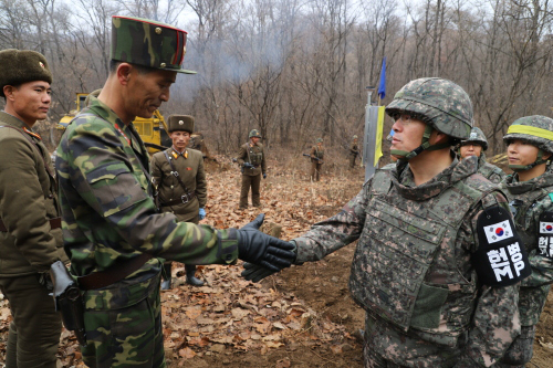 강원 철원 비무장지대(DMZ) 내 남북 도로 연결 사업에 참여한 남북 군인들이 지난주 군사분계선(MDL) 인근에서 만나 악수를 나누고 있다. 국방부 제공