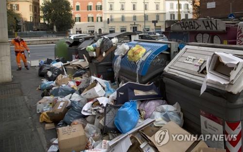 로마 시의 한 주택가에 쌓인 쓰레기 더미 옆에서 한 환경미화원이 머리에 손을 올리고 서 있다. [AP=연합뉴스]