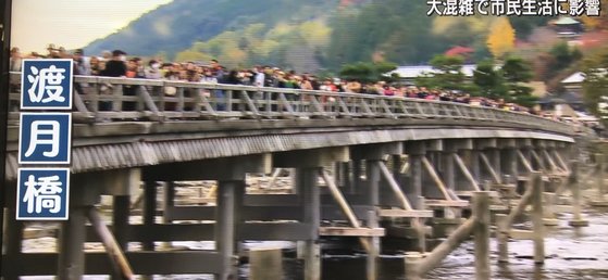 지난 주말 교토의 대표적인 관광지 아라시야마를 상징하는 도게츠교 건너는 관광객들의 모습[TV아사히 화면 캡쳐]