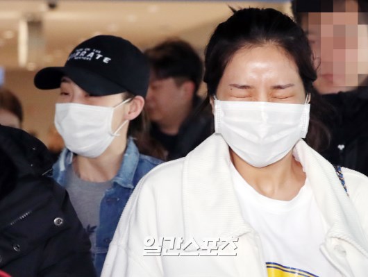 Members of MAMAMOO (Sola, Moonbyul, Wheein, Hwasa) are leaving the airport, cheered by fans.