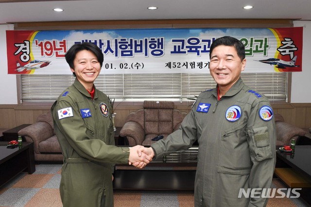 【서울=뉴시스】 여성 최초로 개발시험비행조종사로 선발된 정다정 소령(진)이 입과식에서 제52시험평가전대장 최정욱 대령과 악수를 하고 있는 모습. 2019.01.02. (사진=공군 제공) photo@newsis.com
