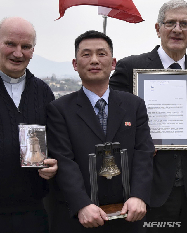 【서울=AP/뉴시스】국가정보원은 3일 조성길 이탈리아주재 북한 대사대리의 망명설과 관련해 "지난해 11월 초 공관을 이탈해 부부가 함께 잠적했다"고 밝혔다.사진은 지난해 3월20일 조성길(가운데) 이탈리아주재 북한 대사대리가 이탈리아 산피에트로디펠레토에서 열린 문화 행사에서 '로베레토 자유의 종'을 들고 있는 모습. 2019.01.03.