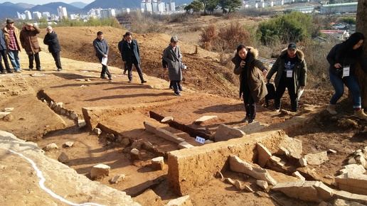 지난달 16일 공개된 함안 아라가야 왕성추정터의 부뚜막 건물터 조사현장에서 조사원이 관계자들에게 설명하고 있다. 이 유적은 가야권에서 처음 드러난 대형 부뚜막 건물터다. 판석을 세워 긴 네모꼴 터를 닦고, 길이 약 5m의 부뚜막과 연기를 빼는 굴뚝자리까지 놓았다.