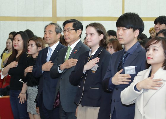 박상기 법무부 장관(가운데)이 지난달 21일 서울 용산구 국립한글박물관 대강당에서 열린 제1회 대한민국 국적증서 수여식에서 국기에 대한 경례를 하고 있다. [법무부 제공]