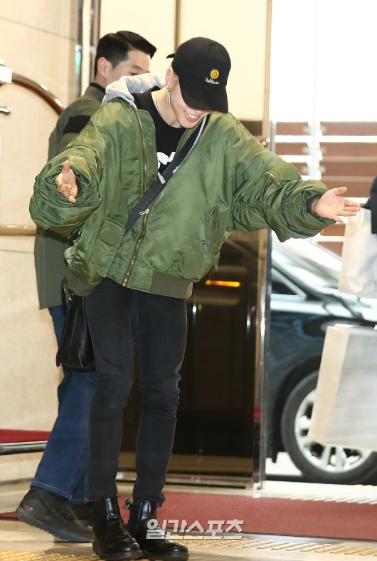 Jimin poses as he enters the arrival hall.