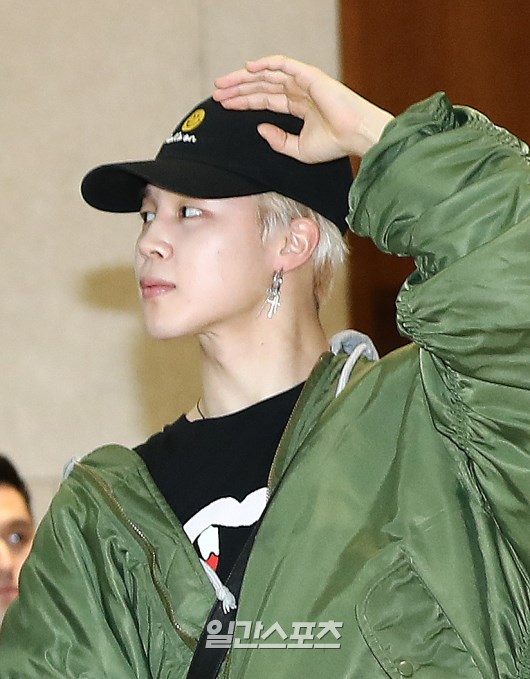 Jimin poses as he enters the arrival hall.