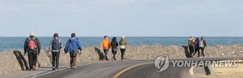 겨울 올레꾼 (제주=연합뉴스) 변지철 기자 = 맑은 날씨를 보인 27일 오전 제주시 한림읍 한림해안로에서 관광객들이 제주올레길 15코스를 걸으며 즐거운 주말을 보내고 있다. 2019.1.27 bjc@yna.co.kr