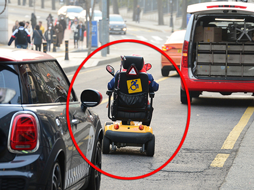 지난 6일 서울 용산구 한 대학교 앞 왕복 2차선 도로. 전동휠체어를 탄 한 시민이 차도에서 저속으로 오르고 있다. 전동 휠체어는 인도로만 다녀야 한다.