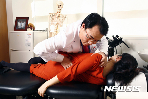 【세종=뉴시스】의료진이 추나요법을 시행하고 있는 모습. (사진=부산대 한방병원 제공)  photo@newsis.com