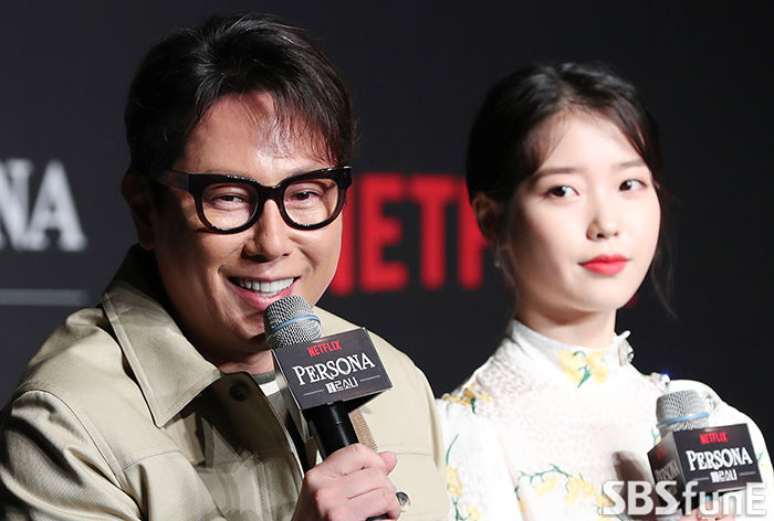 Singer Yoon Jong Shin (left) greets her at a production report for Netflix film Persona at the Conrad Seoul Hotel in Yeongdeungpo-gu, Seoul on the morning of the 27th.