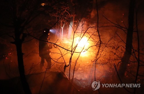 '학생들의 보금자리를 사수하라' (강릉=연합뉴스) 김도훈 기자 = 5일 새벽 산불이 발생한 강원도 강릉시 옥계면 옥계중학교 인근에서 의용소방대원이 화재진압 작업을 벌이고 있다. 2019.4.5 superdoo82@yna.co.kr