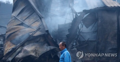 허망함만 남은 마을 (속초=연합뉴스) 김도훈 기자 = 5일 오전 전날 강원도 고성군 토성면에서 시작된 산불이 번진 속초시 장천마을에서 한 주민이 불에 타 무너진 집 앞을 지나고 있다. 2019.4.5 superdoo82@yna.co.kr