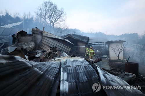 화마가 지나간 자리 (속초=연합뉴스) 김도훈 기자 = 5일 오전 전날 강원도 고성군 토성면에서 시작된 산불이 번진 속초시 장천마을에서 완전히 타버린 가옥 근처에서 소방대원이 잔불 진화 작업을 벌이고 있다. 2019.4.5 superdoo82@yna.co.kr