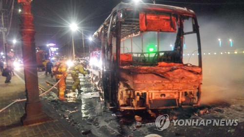 불에 탄 버스 진화 (속초=연합뉴스) 이종건 기자 = 4일 오후 7시 17분께 강원 고성군 토성면 원암리 산에서 난 산불이 확산해 속초시 한 도로에서 버스가 불에 타자 소방대원이 진화하고 있다. 2019.4.4 momo@yna.co.kr