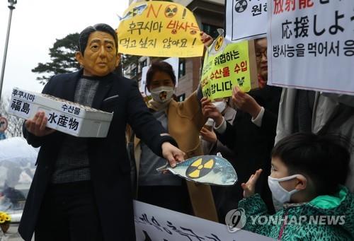 '후쿠시마 방사능 오염 수산물 거부' (서울=연합뉴스) 김주성 기자 = 19일 서울 종로구 옛 일본대사관 터 앞에서 열린 '일본산 식품 수입규제 WTO 패소 대응 촉구 기자회견'에서 아베 신조의 가면을 쓴 한 참가자가 후쿠시마 방사능 오염 수산물을 강요하는 일본 정부를 규탄하고 WTO 패소에 대한 정부 대응을 촉구하는 퍼포먼스를 벌이고 있다. 2018.3.19