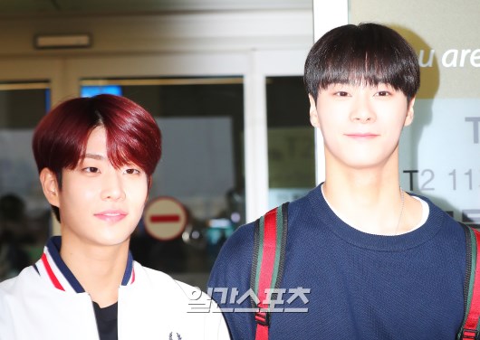 MJ and Moon Bin are posing as they enter the departure hall.