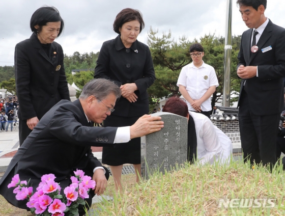 【광주=뉴시스】박진희 기자 = 문재인 대통령과 부인 김정숙 여사가 18일 오전 광주 북구 국립5·18민주묘지에서 열린 '제39주년 5·18민주화운동 기념식'을 마치고 5·18희생자 고 김완봉 묘역을 찾아 참배하고 있다.   고 김완봉(66년 7월 24일부터 80년 5월 21일)씨는 친구와 절을 간다며 길을 나셨다가 사망했고, 어머니는 적십자병원에서 아들 시체를 찾았고 29일까지 아들을 지키다가 묘역에 안장했다. 2019.05.18.    pak7130@newsis.com