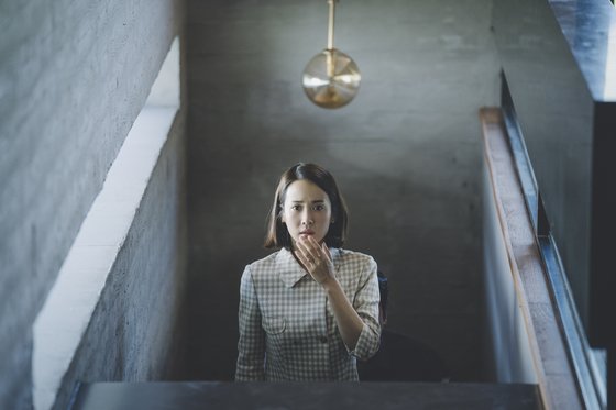 거실로 올라오는 계단에 선 연교. 그의 등 뒤 센서등을 포함해 이 계단에선 여러 번 결정적 장면이 연출된다. [사진 CJ엔터테인먼트]