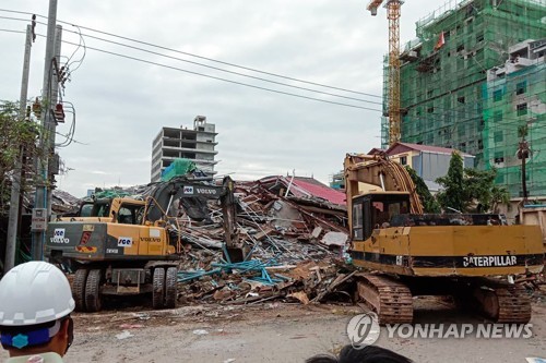 2019년 6월 22일 캄보디아 남서부 항구도시인 시아누크빌에서 중국 기업 소유의 7층 빌딩이 붕괴한 현장에서 구조대원들이 중장비를 동원해 잔해를 치우고 있다. [AFP=연합뉴스]