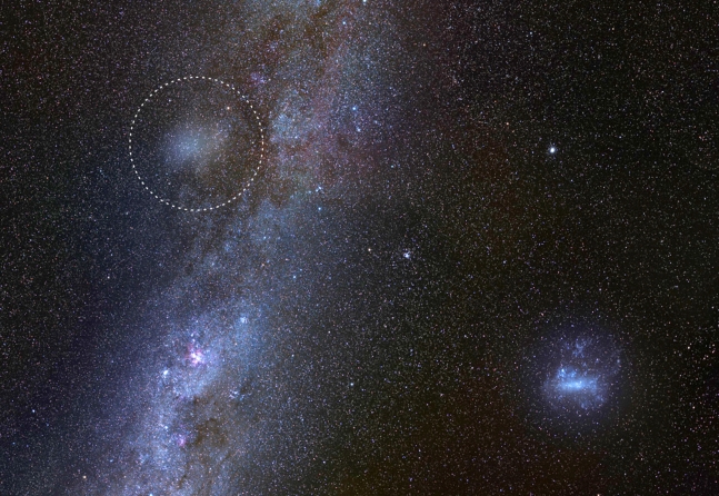 지구에서 관측한 ‘유령 은하’ 안틀리아 2(왼쪽 상단 점선 동그라미)와 우리 은하(왼쪽 하단), 그리고 대마젤란은하(오른쪽 하단)의 모습.(사진=가브리엘 토렐바, 바실리 벨로쿠로프, 세르주 브루니에/유럽남방천문대(ESO))