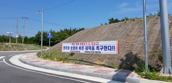 지난 4일 양파와 마늘 주산지인 서산시 부석면의 도로변에 정부와 농협에 대책 마련을 촉구하는 현수막이 걸려 있다. 농민들은 "인건비도 못 건진다"고 하소연했다. 신진호 기자