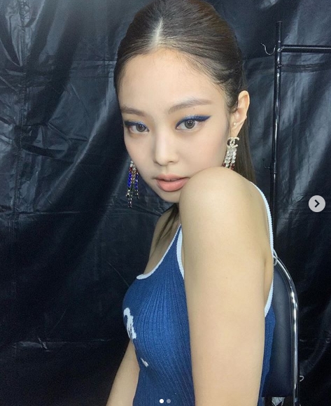Girl group Black Pink Jenny Kim showed off intense makeup visuals.Jenny Kim posted several photos on her Instagram account on Wednesday.Jenny Kim, who visited the local area for the Bangkok Angkor concert in Thailand, shot her at various angles in the waiting room.Jenny Kim, who matched white hot pants with a blue one-shoulder top with a luxury brand logo, boasted a superb beauty with a colorful blue eye makeup.Fans responded by saying, Its a goddess and My beauty is crazy.