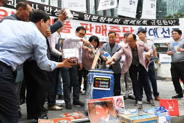 “일본산 음료·과자도 안팔아” 한국중소상인자영업자총연합회 관계자들이 15일 서울 종로구 옛 주한일본대사관 앞에서 일본산 의류·맥주 등을 쓰레기통에 버리는 퍼포먼스를 하고 있다./오승현기자