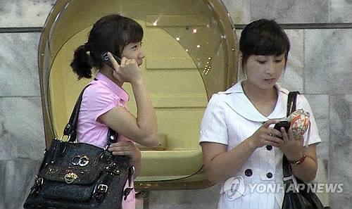 휴대전화 사용하는 북한 주민 [2013년 어린이의약품지원본부 제공]