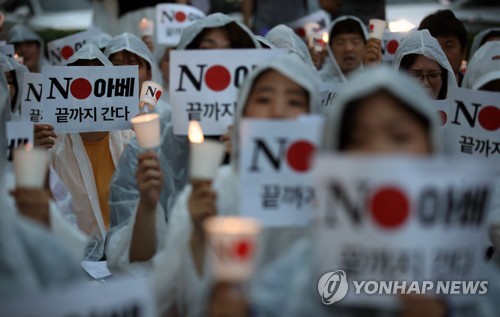 빗속에서의 외침 (서울=연합뉴스) 박동주 기자 = 25일 서울 종로구 주한일본대사관 앞에서 일본제품 불매운동 참가 사연 등을 밝히는 '일본대사관 앞 시민 촛불 발언대'에서 참가자들이 구호를 외치고 있다. 2019.7.25 pdj6635@yna.co.kr