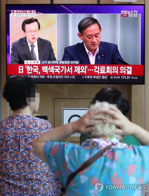 (서울=연합뉴스) 박동주 기자 = 일본 정부가 각의에서 전략물자 수출 간소화 대상인 백색국가에서 한국을 제외하는 수출무역관리령 개정안을 결정한 지난 2일 서울역에서 시민들이 스가 요시히데 일본 관방장관의 브리핑 화면을 보고 있다. pdj6635@yna.co.kr