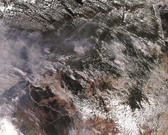 미국 항공우주국(NASA) 소속 지구관측위성 ‘아쿠아’가 지난 13일(현지시간) 촬영한 브라질·볼리비아 국경 인근 아마존 열대우림 상공의 모습. 대형 화재가 일으킨  연기가 곳곳에서 보인다. AP연합뉴스