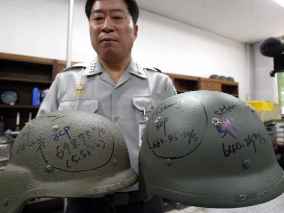 2004년 8월 당시 새로 도입한 방탄헬멧 성능비교시험에서 김희재 육사 무기공학과 교수가 국산 헬멧(오른쪽)과 미군 헬멧의 실험 결과를 보여 주고 있다. 연합뉴스