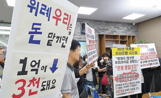 독일 국채금리 연계형 파생결합증권(DLS)에 투자했다가 거액을 날린 투자자들이 19일 오전 경기 성남시 수정구 우리은행 위례신도시지점에 몰려들어 항의 시위를 벌이고 있다. 이들은 "독일이 망하지 않는 한 절대 안전하다더니, 1억원이 6개월 새 3000만~4000만원이 됐다"며 원금을 돌려달라고 호소했다. /위례=김은정 기자