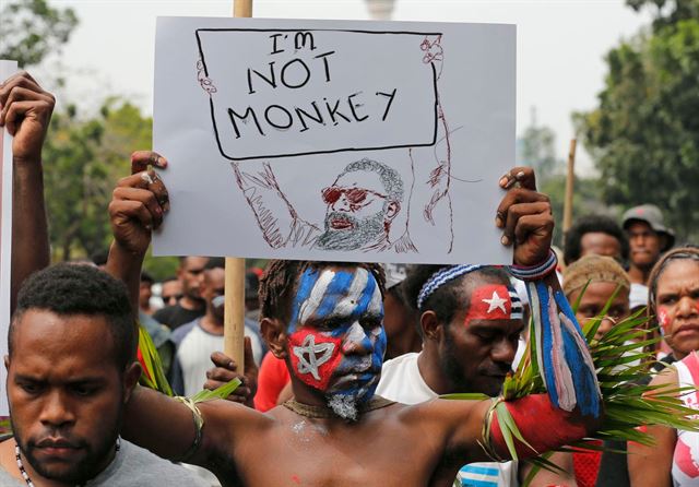 지난달 28일 인도네시아 수도 자카르타 대통령궁 일대에서 벌어진 파푸아 출신 주민들의 반정부 시위에서 시위대가 독립을 상징하는 샛별을 얼굴에 그리고 '나는 원숭이가 아니다'라는 팻말을 들고 있다. 자카르타=AP연합
