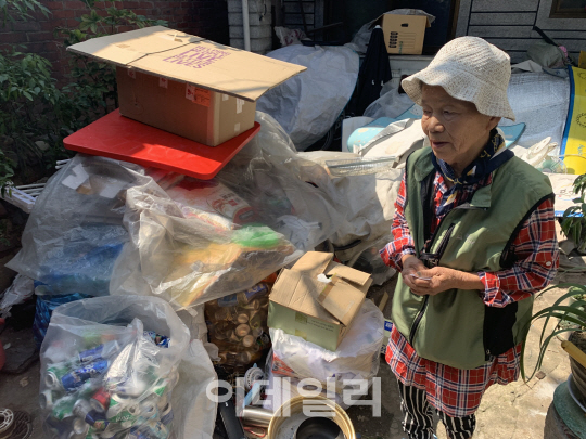 마당에 쌓인 폐지와 고물을 바라보는 장선순(79)씨. (사진=황현규 기자)