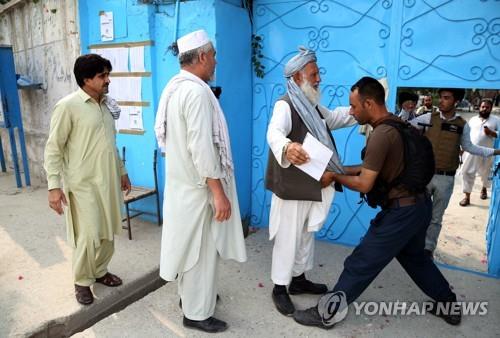 28일 아프간 잘랄라바드 대선 투표소에서 치안 병력이 유권자의 몸을 조사하고 있다. [EPA=연합뉴스]