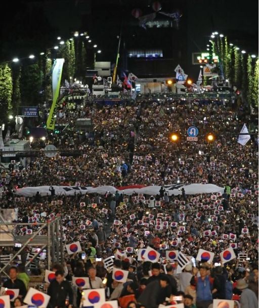 지난 5일 오후 서울 서초구 서초역 사거리에서 열린 ‘8차 검찰개혁 촛불 문화제’에 참석한 이들이 태극기 퍼포먼스를 펼치고 있다. 연합뉴스